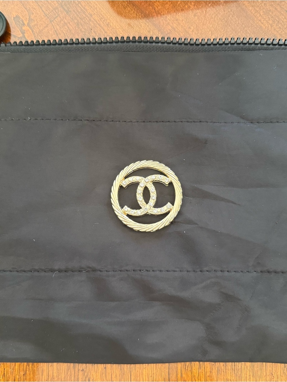 CHANEL Black cosmetic bag with White CC Emblem and a gold CC on the other side. - Picture 4 of 6